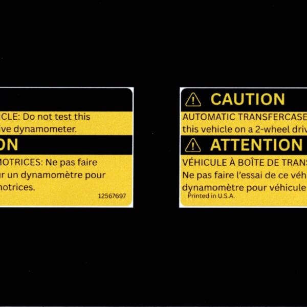Flat scan of GM 12565610 transfer case caution and 12567697 AWD warning label reproductions